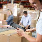 Worker Using Tablet Computer In Distribution Warehouse